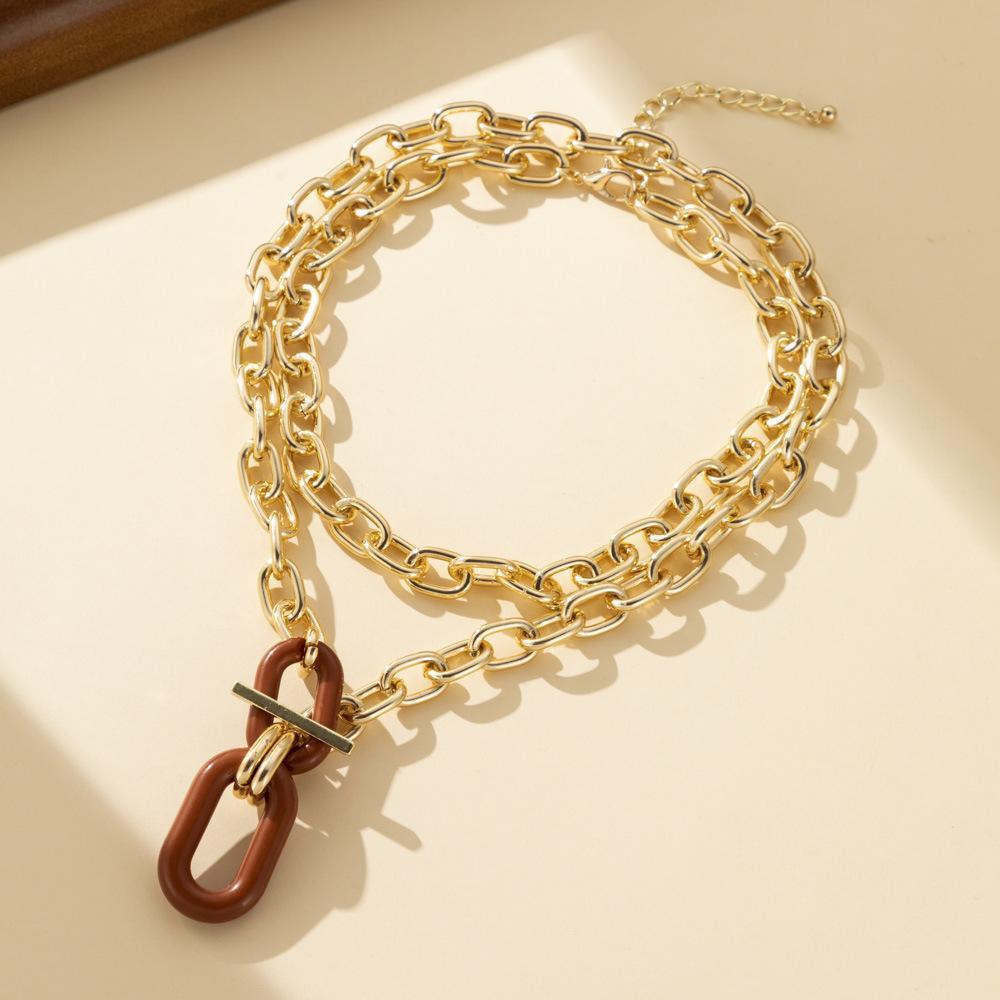  Chunky gold chain necklace with a brown geometric pendant, featuring a stylish toggle clasp and an adjustable chain, displayed on a neutral background. Perfect for bold and trendy fashion looks.